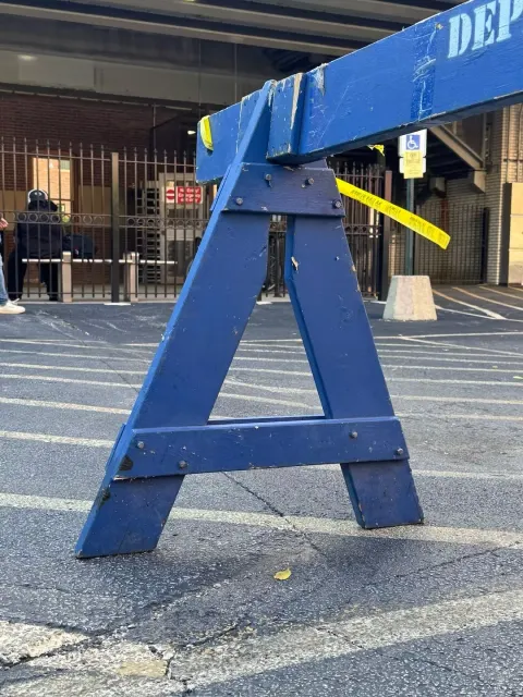 A blue sawhorse barrier shaped like the letter A